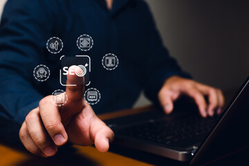 A person interacts with a laptop, focusing on SEO-related icons, symbolizing digital marketing and online strategy.