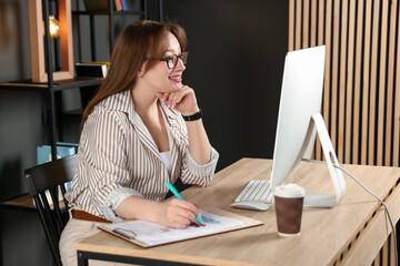 Obraz premium Designer drawing sketch of clothes at wooden table in office