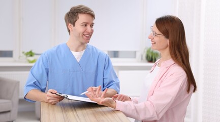 Obraz premium Medical assistant helping patient at reception in clinic