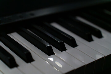 A close-up view of piano keys showing black and white keys under soft lighting. The image conveys a mood of music, creativity, art, and elegance