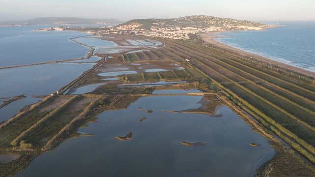 Aerial drone footage of a Mediterranean sandbar separating coastal lagoons and the sea near S&egrave;te, Marseillan, and Agde in southern France.