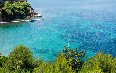 Clear turquoise sea with floating safety buoys marking swimming area in Montenegro. Coastal tranquility, summer relaxation, marine clarity and peaceful seaside environment for leisure and outdoor