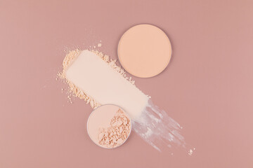 Cosmetic compact powder on pink background