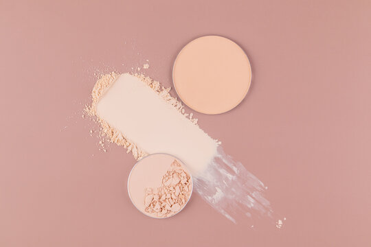 Cosmetic compact powder on pink background