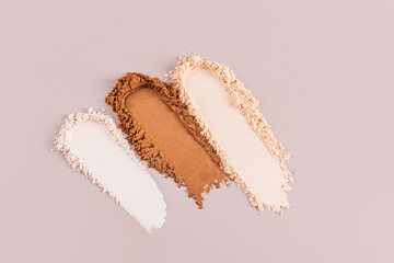 Three shades of compact powders on a neutral background