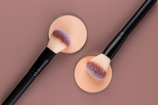 Compact powder and brush set on neutral background