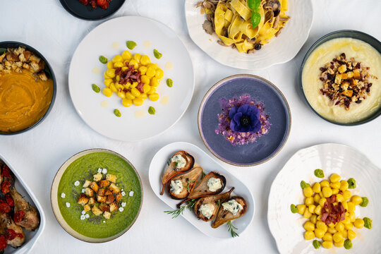 Italian gourmet food spread, traditional dishes flat lay on white table