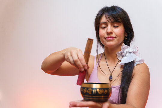 Woman practicing yoga meditation with Tibetan bowl
