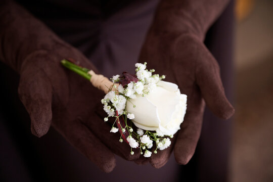 Elegant wedding flower held in gloved hands