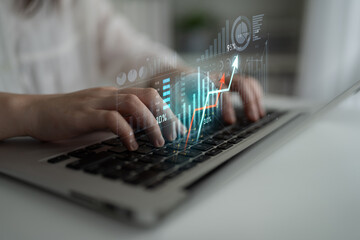 Close-up of hands typing on a laptop with digital graphs and charts overlay, showcasing the integration of technology and finance in data analysis and business growth. Scalp