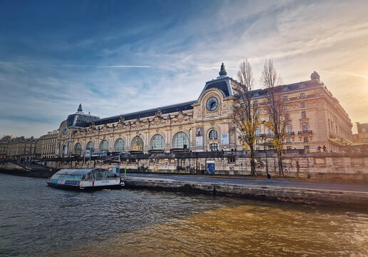 Paris, France - December 09, 2025: View from a cruising boat along the Seine River to the Orsay museum. Beautiful building with monumental clock and Beaux-Arts facade