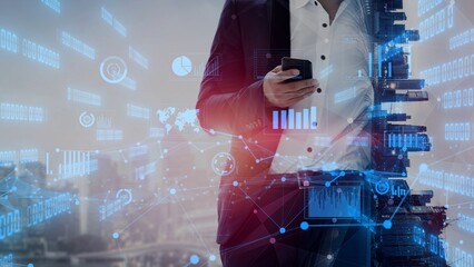 A business professional stands confidently in a modern urban setting, using a smartphone while surrounded by innovative digital overlays of data and analytics concepts. Xenic