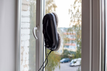 Cleaning robot cleans the inside of apartment windows. Modern household cleaning products. Modern device for removing dirt from glass.