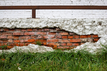 Exposed old brick wall with peeling plaster texture. Background with texture of old dirty brick wall and cement.