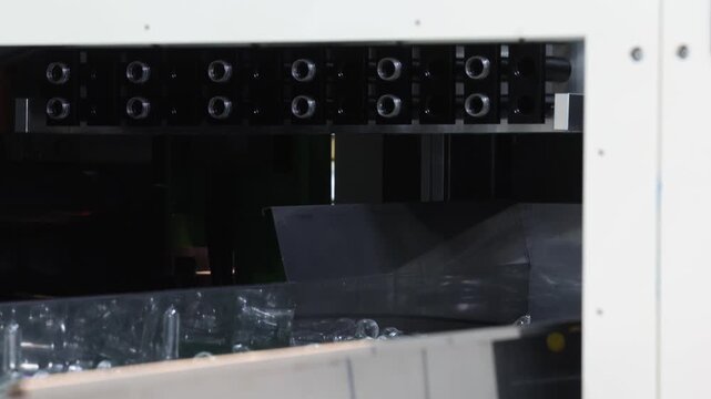 Plastic bottle preforms. Making of Transparent PET plastic preforms move along automated conveyor belt in factory. Industrial production line concept for plastic bottle packaging automation recycling