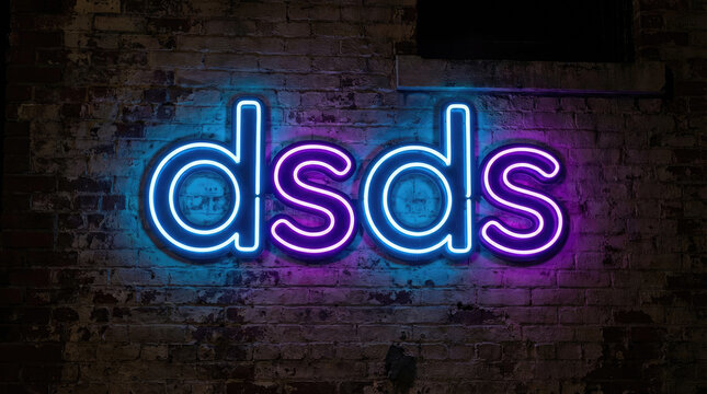 Dsds text in neon style with blue and purple colors on a dark textured surface creating a vibrant and modern aesthetic