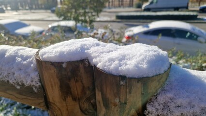 Snow covering wooden fence posts on a sunny winter day