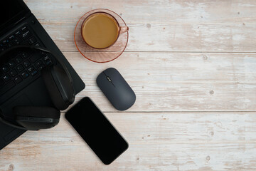 Top view business workspace with laptop, smartphone, mouse, headphones, and coffee on white wooden desk representing productivity, remote work, digital focus, and professional office setup.