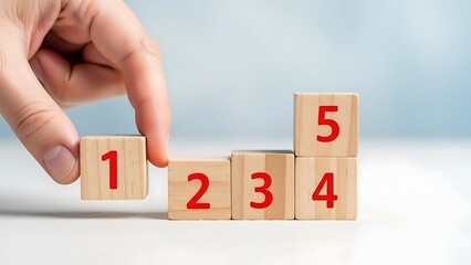 Hand arranging wooden blocks in ascending order with numbers on white background