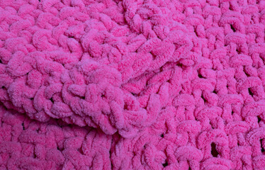 Fluffy cardigan with a chunky knit pattern in pink for background and texture use
