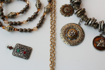 Set of women&rsquo;s fashion accessories, including metal necklaces and earrings. Horizontal studio shot with white background, ideal for beauty and feminine themes, costume jewelry and lifestyle content.
