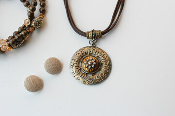 Brown necklaces and earrings on white background with copy space. Perfect for women fashion, personal accessories and elegant costume jewelry.