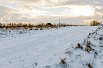 Snow covered rural road under winter sky.