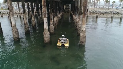 Remotely operated vehicle ROV maneuvering around submerged marina pilings capturing highresolution footage for detailed foundation assessment.