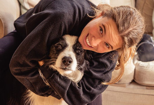 Woman hugging old border collie dog demonstrating love