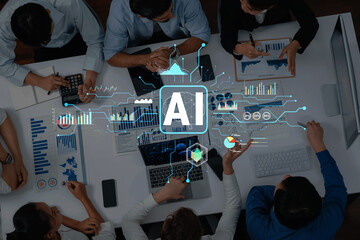 A business team gathers around a table to collaborate on an artificial intelligence project, utilizing data analysis and digital tools in a modern office setting. Trope