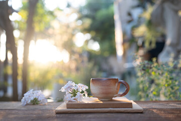 Earthenware vintage brown clay coffee cup and flowers and notebooks