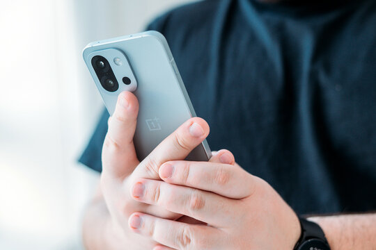 KYIV, Ukraine, January 5, 2026. Person holding  OnePlus 13S or 13T smartphone in hands, modern mobile technology concept, messaging, communication, everyday digital lifestyle.