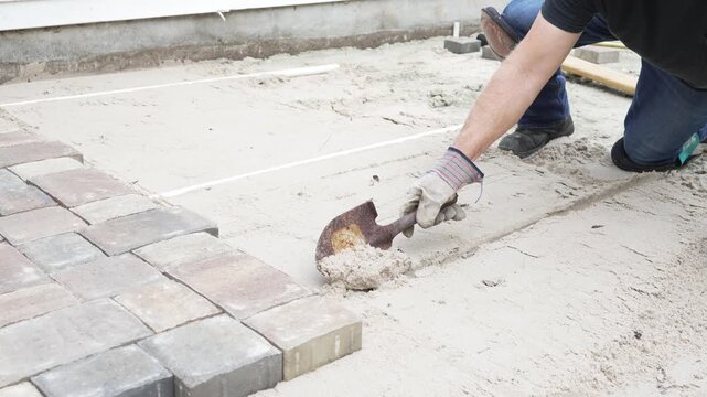 Man working on his home DIY project building a paver patio in his back yard