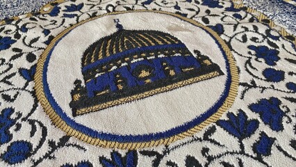 Prayer rug motif with Islamic-style mosque and dome ornaments, featuring detailed fabric textures and decorative patterns. © RiyanBudi