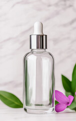 Naklejka premium A sleek glass dropper bottle stands elegantly beside a vibrant pink flower and green leaves, perfect for showcasing skincare products or essential oils.