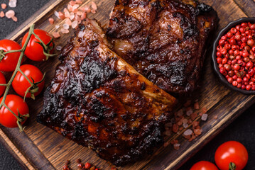 Grilled or barbecued pork or beef ribs, meat with red sauce for the dinner table. Grilled ribs