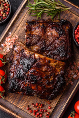 Grilled or barbecued pork or beef ribs, meat with red sauce for the dinner table. Grilled ribs