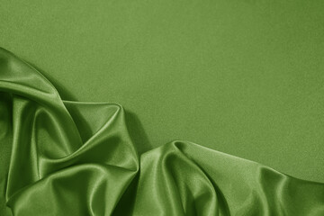 Light soft green lime pistachio silk satin. Shiny silky smooth fabric. Wavy folds. Draped. Elegant background. Empty blank space template design ad.Christmas festive birthday.Flat lay, top view table.