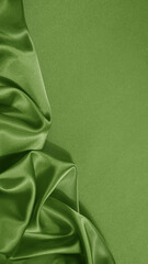 Light soft green lime pistachio silk satin. Shiny silky smooth fabric. Wavy folds. Draped. Elegant background. Empty blank space template design ad.Christmas festive birthday.Flat lay, top view table.