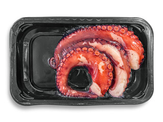 Pre-cooked octopus tentacles vacuum-packed in black plastic trays isolated