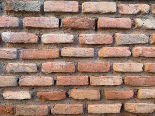 Rough weathered brick wall displaying a textured pattern, representing strength and durability