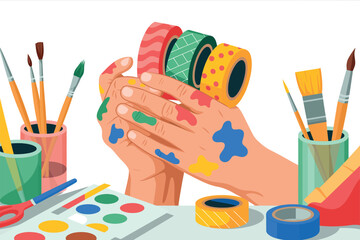 Hands covered in colorful paint are holding rolls of decorative tape amidst art supplies.