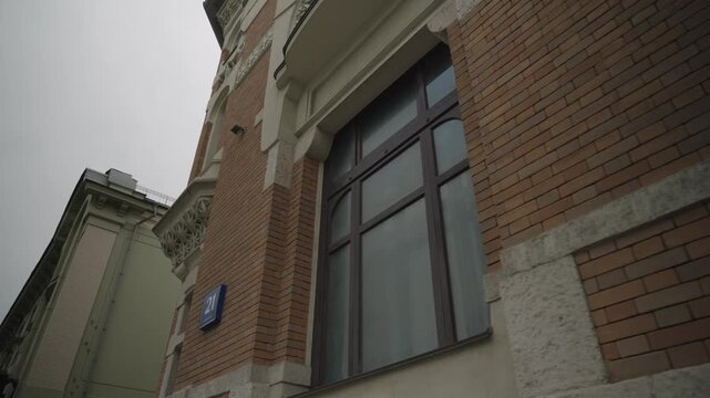 The facade of a historic brick building with stucco. Bottom view. Filmed in motion