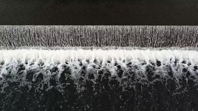Kleiner Wasserfall an einem Wehr im Fluss
