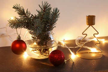 Christmas composition with pine branches red ornaments garland and tree shaped candle holder.