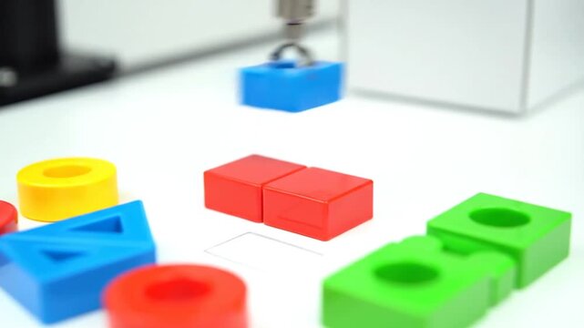Robotic Arm Assembling Colorful Toy Blocks on a White Table Automation and Precision in Engineering Close Up Shot Box