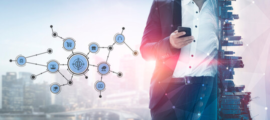 A business professional standing with a smartphone, symbolizing technology and connectivity against an urban skyline, representing modern communication in business. Tessel