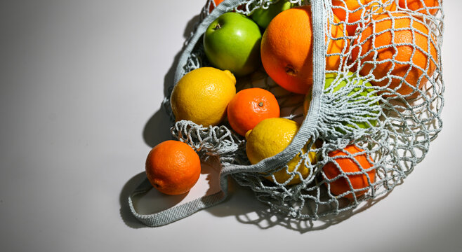Light Blue Net Bag with Various Citrus Fruit and Green Apples