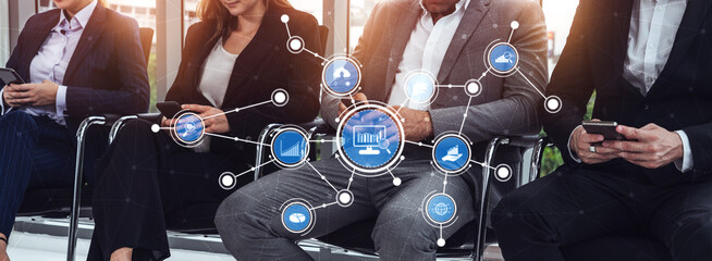 Group of professionals in business attire sitting and using smartphones, showcasing the blending of technology and communication in a modern corporate environment. Tessel