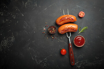 Grilled sausages fork ketchup spices bbq barbecue tomato black background copy space